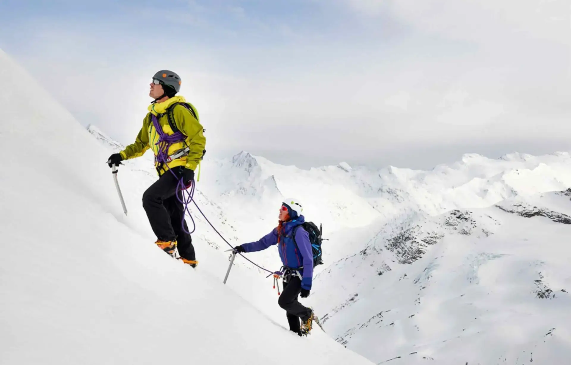 Mountaineers climbing a steep snow slope in the Alps